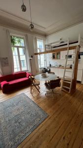 布鲁塞尔Arti Appart Louise/Flagey/Centre的客厅配有红色的沙发和高架床