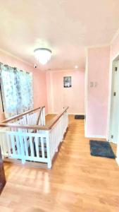 公主港Fely's transient house的客房设有楼梯、粉红色的墙壁和木地板