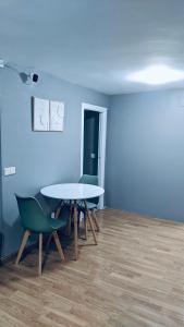 马德里Hostel 165的配有桌椅和蓝色墙壁的客房