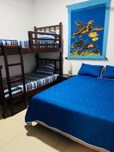 蓬塔雷纳斯CasaLu的一间卧室配有蓝色的床和两张双层床。