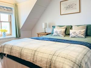 阿普尔克罗斯The Fishermans Cottage的一间卧室配有一张带蓝白色床单的大床