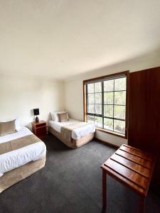 斯特拉恩Risby Cove Boutique Hotel的酒店客房设有两张床和窗户。