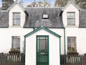 阿普尔克罗斯The Fishermans Cottage的白色的房子,设有绿门和围栏