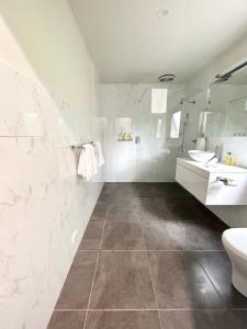斯特拉恩Risby Cove Boutique Hotel的白色的浴室设有卫生间和水槽。