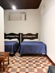 危地马拉Hotel Letona的一张位于带 ⁇ 形地板的客房内的两张床
