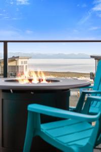 坎贝尔河Ocean View Townhouse #30 at THE BEACH HOUSE的海滩上的桌子、椅子和火坑
