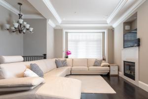温哥华Rare Find Exquisitely New Quiet & Safe Skytrain Home的客厅配有白色沙发和壁炉