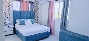 圣佩德罗-德马科里斯Casa familiar的一间卧室配有蓝色的床和蓝色椅子