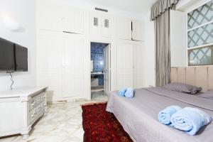 拉马萨Arabesque House的一间卧室配有一张带蓝色毛巾的床