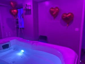 孔夫朗-圣奥诺里讷Jacuzzi privé arrivée autonome的粉红色的浴室,墙上有心,设有浴缸