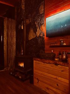 贾马里海姆森AYDER BUNGALOW - river view , Royal Bungalow Resorts的客厅设有壁炉和平面电视。