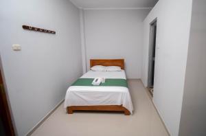 塔拉波托Humazapa的一间小卧室,在白色的房间里配有一张床