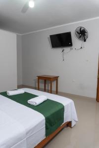 塔拉波托Humazapa的卧室配有一张床铺,墙上配有电视