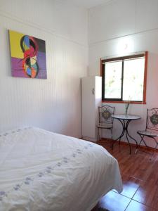柯纳里佩Alojamiento Ximena的一间卧室配有一张床、一张桌子和一个窗户。