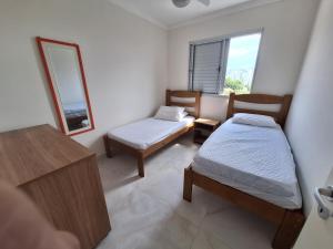 伯迪亚哥Apto em Bertioga , pé na areia的一间小卧室,配有两张床和镜子