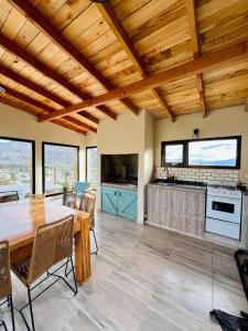 埃斯克尔Refugio del Pescador的一间厨房和带木制天花板的用餐室