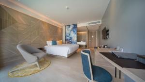 芭东海滩The Nature Phuket - SHA Extra Plus的一间卧室配有一张床和一张桌子及椅子