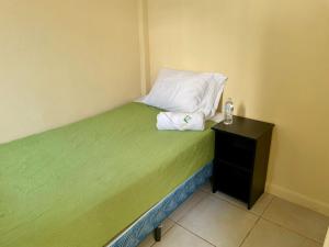 危地马拉Casa Quetzal的一张带枕头的小床和一个床头柜