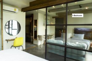 曼谷karaarom hotel的一间卧室配有两张床和一张黄色椅子