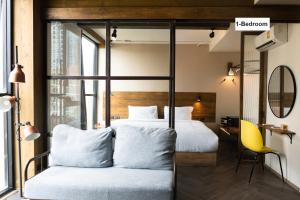 曼谷karaarom hotel的一间卧室配有两张床和一张黄色椅子