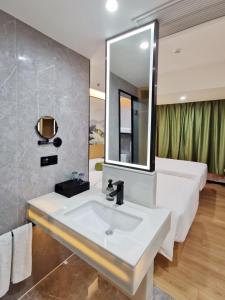 深圳广纳酒店（深圳福田店）的浴室设有白色水槽和镜子