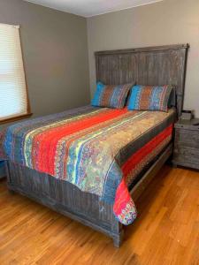 德梅因Whole Home MidCentury - Quiet & Close to Downtown的一间卧室配有一张大床和木制床头板