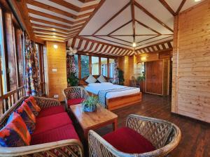 西姆拉Hotel Pineview Shimla的一间卧室配有一张床、两把椅子和一张桌子