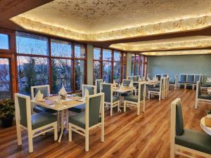 西姆拉Hotel Pineview Shimla的用餐室设有桌椅和窗户。