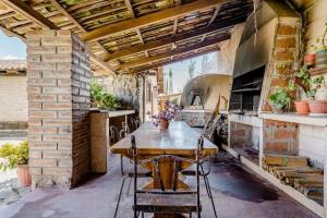 伊瓦拉Quinta María Alfonsina的户外厨房配有木桌和烤箱