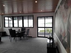 维拉港Crystal Beach Hotel的一间带桌椅和窗户的用餐室