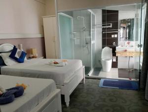 维拉港Crystal Beach Hotel的浴室设有两张床和玻璃淋浴间。