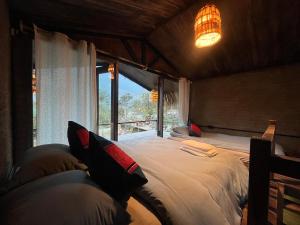 萨帕La Maison SAPA - Bungalows的一间卧室设有一张大床和一个窗户。