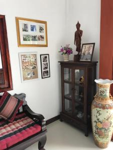 素可泰Phiphu Art and Gallery Boutique Sukhothai的一间带椅子和花瓶的客厅