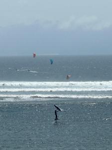 HuuLakey Peak B and B的海风筝的人站在海滩上