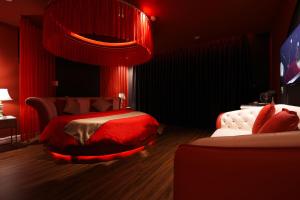 岘港Chiic House 1 - Khách sạn tình yêu的红色卧室设有一张红色天花板的床