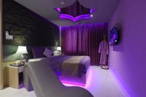 岘港Chiic House 1 - Khách sạn tình yêu的紫色卧室,配有紫色照明床
