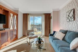 拉斯维加斯Serenity Suite的客厅配有蓝色的沙发和玻璃桌