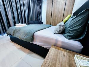 古晋Kozi Square Twin Room with free Wi-fi & Carpark的一间卧室配有一张带绿色枕头的床。