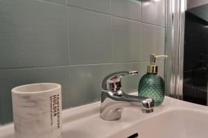 米茹Le Montagnard的浴室水槽配有水龙头和一卷卫生纸