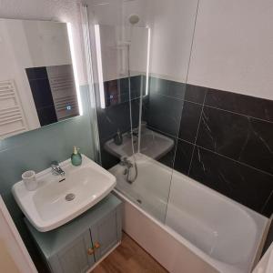 米茹Le Montagnard的一间带水槽、浴缸和镜子的浴室
