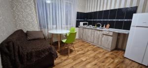 克洛佩夫尼茨基Yanovskogo 1k Shin的一间卧室配有一张床铺和一张桌子,还设有一间厨房