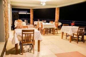 RutsiroKARIBA SUN BEACH APARTMENT的餐厅配有桌椅和白色的桌布