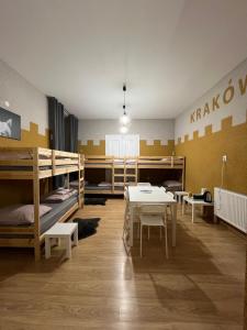 克拉科夫Girls Hostel的客房设有双层床和桌椅。
