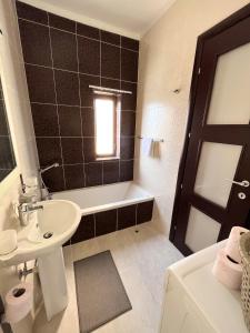卢加Modern Spacious 2BD Penthouse with 2 Terraces - Close to Luqa Airport的一间带水槽、浴缸和卫生间的浴室