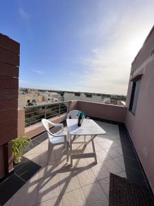 卢加Modern Spacious 2BD Penthouse with 2 Terraces - Close to Luqa Airport的阳台上配有一张白色的桌子和两把椅子