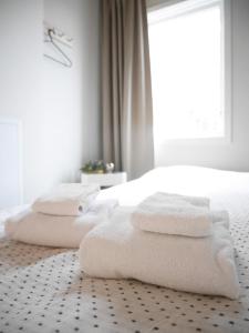UndenäsCozy Hilltop Cottage With Fantastic View的白色卧室,床上配有白色毛巾