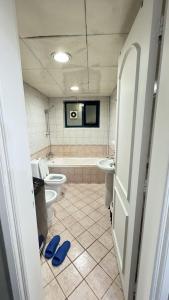 迪拜Golden Horse Hostel的浴室配有2个卫生间、浴缸和水槽