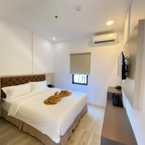 名古屋BATAM 1 HOTEL的卧室配有白色的床和棕色毯子