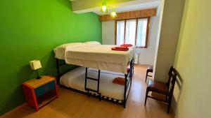 哈卡Vivac Jaca的带两张双层床的绿色墙壁客房
