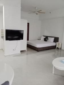 吉隆坡BBS APARTMENT AT TIMES SQUARE KUALA LUMPUR MALAYSIA的白色的客房配有床和平面电视。